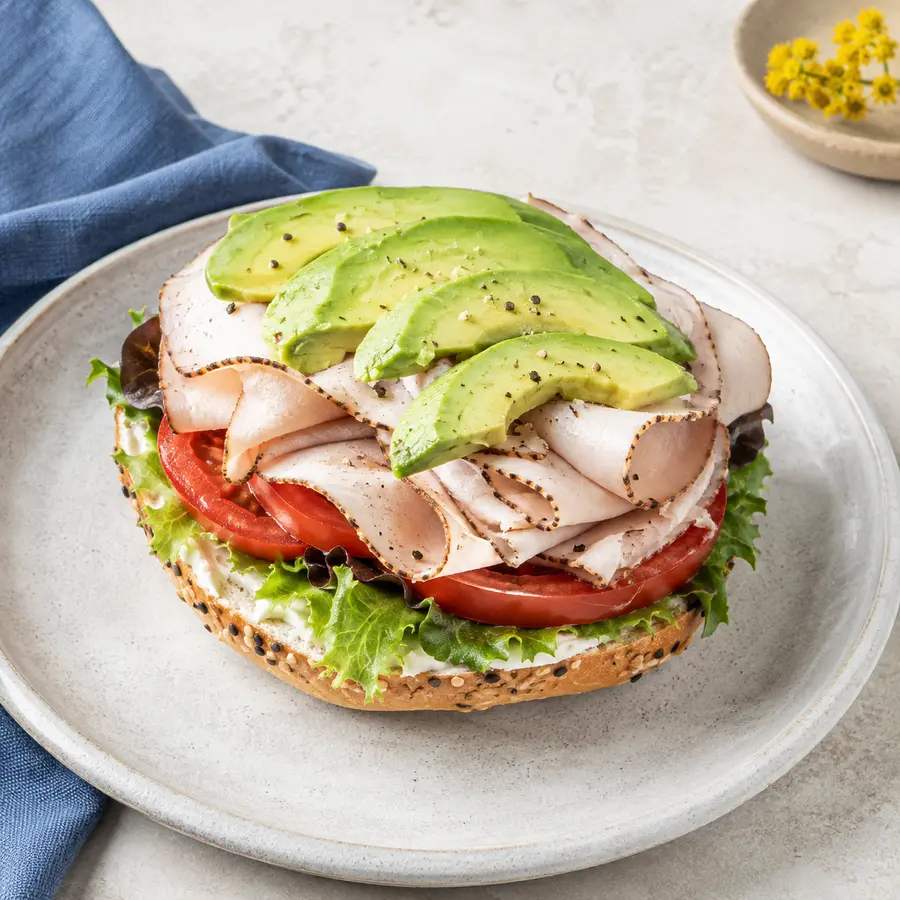 Turkey Avocado bagel with tomato and greens